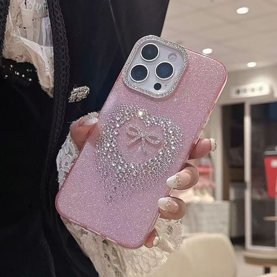 Person holding a pink phone case with a bow design in an indoor setting